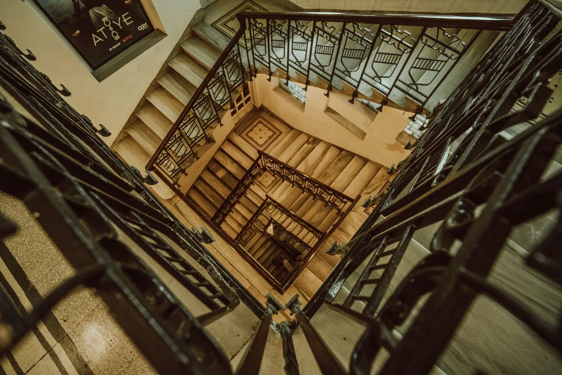 Elegantes Berliner Altbau-Treppenhaus mit geschwungenem Geländer und hohen Decken
